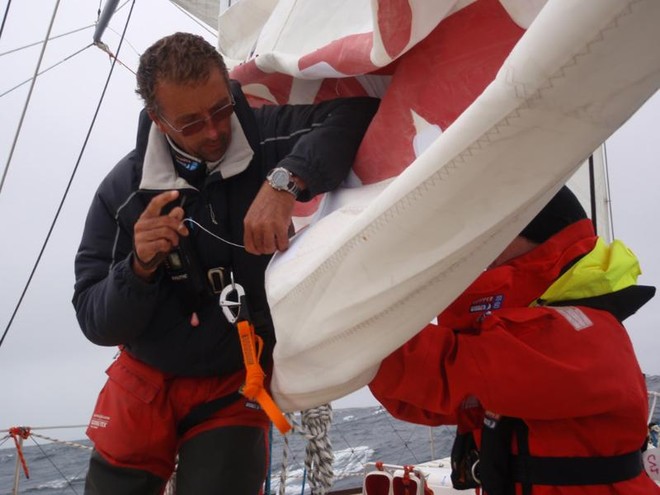 Pete Stirling and Heather Covey repair the mainsail on Jamaica Lightning Bolt - Clipper 09-10 © Clipper Ventures PLC . http://www.clipperroundtheworld.com